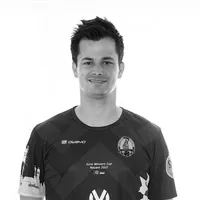 Un hombre lleva una camiseta deportiva personalizada en blanco y negro con un patrón geométrico, el logo de owayo, un escudo de club y la inscripción 'Euro Winners Cup Nazaré 2022'.