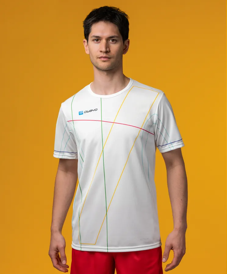 Un modelo masculino viste una camiseta deportiva blanca con patrones de líneas coloridas sobre un fondo amarillo.