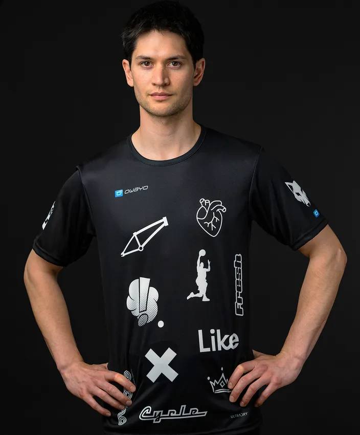 Un hombre lleva una camiseta deportiva negra con varios símbolos y logotipos blancos.