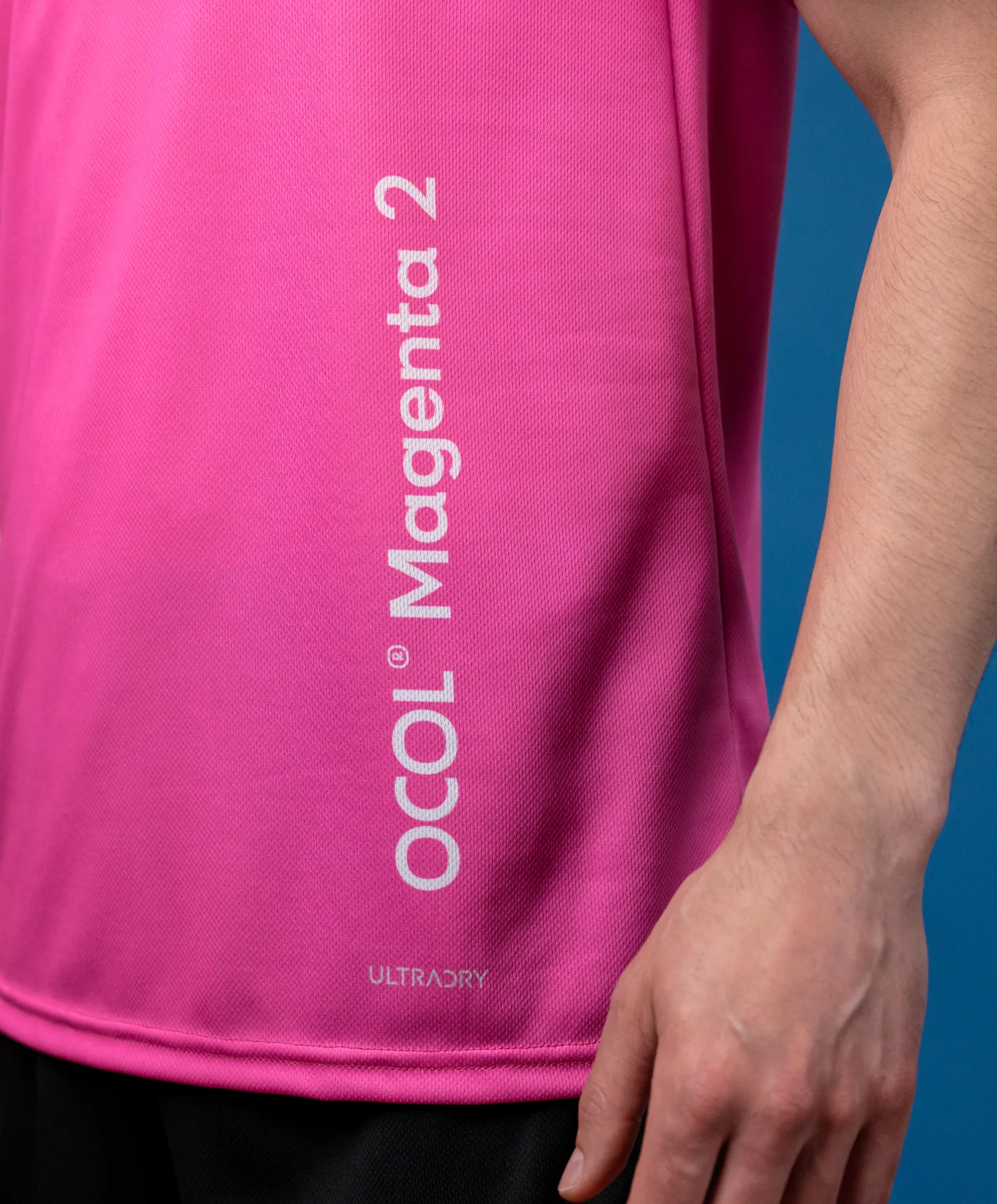 Una camiseta deportiva rosa con un logo y el texto 'Magenta 2'.